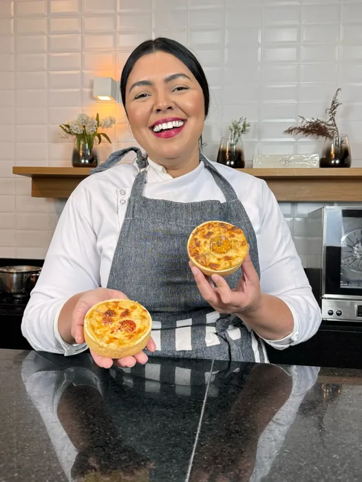 Chef Geicy segurando duas quiches francesas recém-assadas