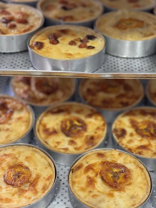 Bandejas de quiches douradas saindo do forno